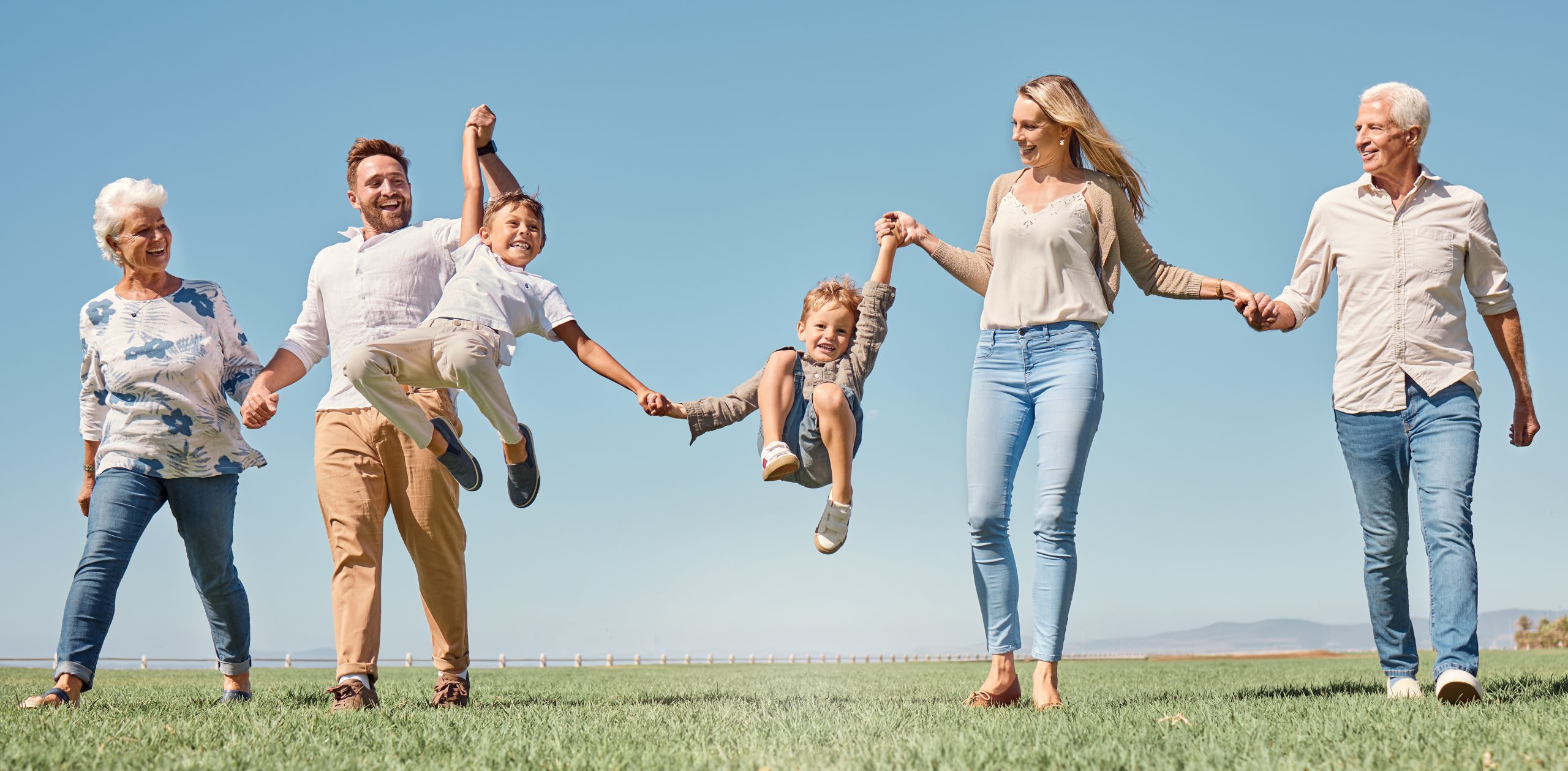 Happy multi-generational family outdoors, symbolizing the benefits of life insurance protection.